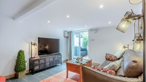 Een moderne woonkamer met een flatscreen televisie, een leren bank en een salontafel.