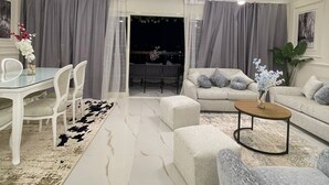 A modern living room with a dining table, sofas, and a coffee table.
