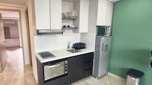 A compact kitchen with a microwave, refrigerator, sink, and a small oven. - Cold AC K Fast WiFi Medellin Paradise (Medellín)