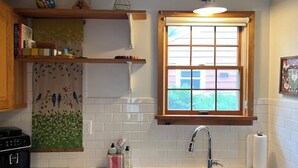 A kitchen with a window, a sink, and a countertop with various items.