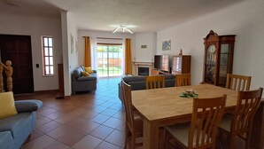 Un'ampia zona giorno con tavolo da pranzo, divani e camino.