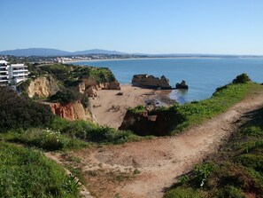 A coastal path leading to a beach with rocky outcrops and a clear view of the sea. - Villa Praia Porto e Mós (Lagos)