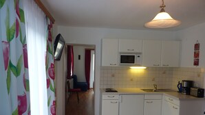A compact kitchen with white cabinets, a microwave, a coffee maker, and a sink. - Vacation apartment DIRECTLY at the lift in the Ski Amadé - Haus Daniel Schartner Kleinarl (Kleinarl)