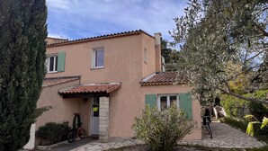 Una casa de dos pisos con techo de tejas, entrada de piedra y camino de grava.