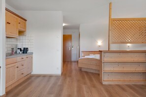 A bedroom with a wooden bed, a wooden headboard, and a nightstand.