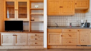 Una cocina con armarios de madera, una encimera, un fregadero y una cafetera.