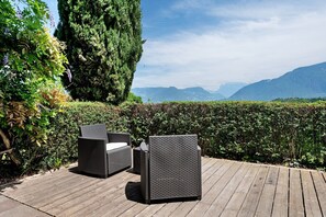 Terraza con mobiliario de mimbre y vista a las montañas.