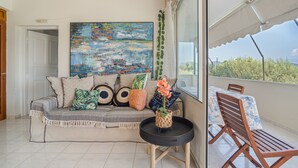 A balcony with a sofa, a table, and a chair. - Apartment 'Theodoros  1' with Sea View, Wi-Fi and Air Conditioning (Nikiana)