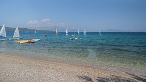 Ein Strand mit Booten und blauem Himmel.
