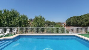 Ein klares, blaues Schwimmbecken mit weißen Liegestühlen und einer dekorativen Umrandung.
