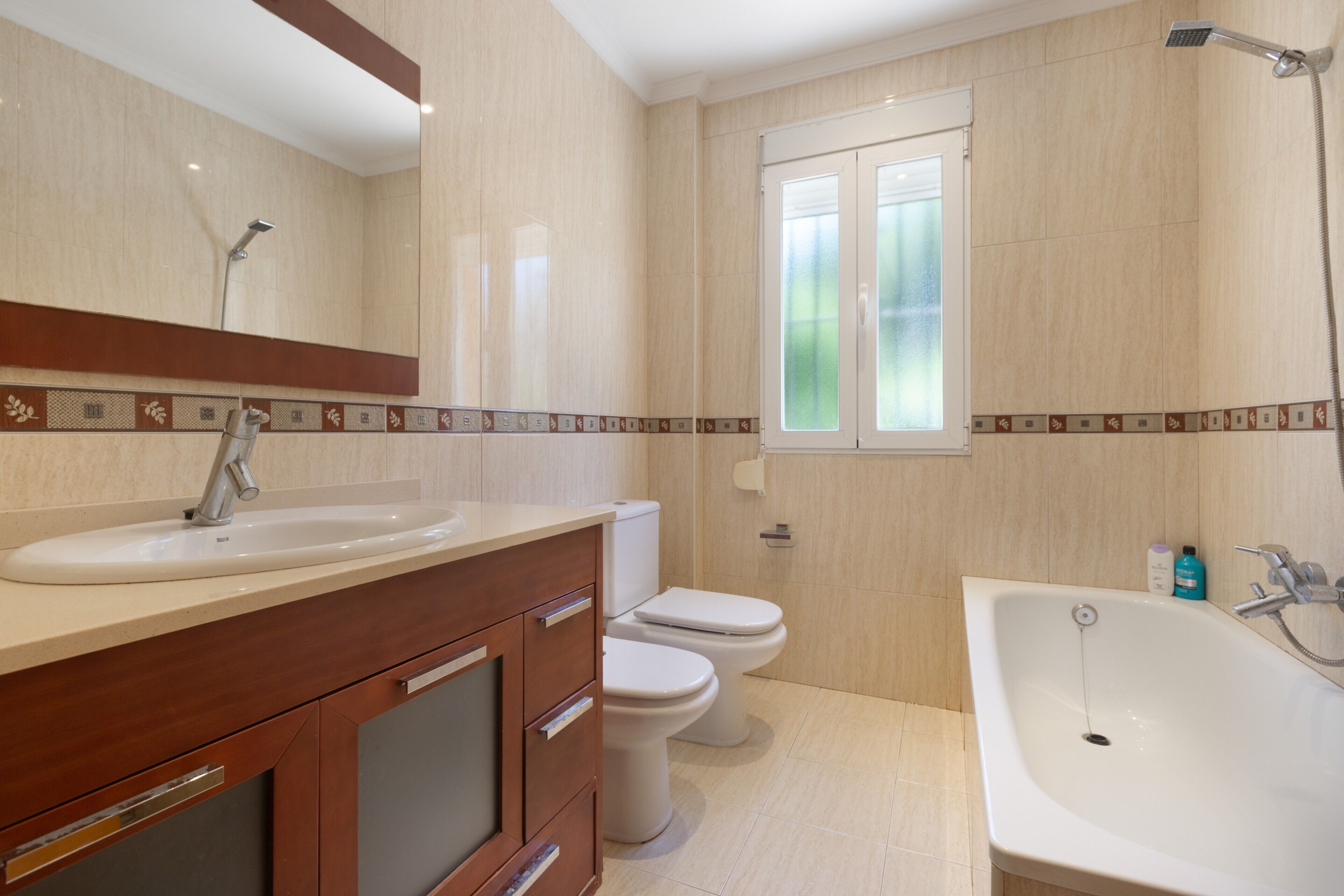 A bathroom with a sink, toilet, and bathtub.