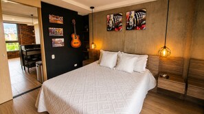 A bedroom with a bed, a guitar, artwork, and a view of the outside. - Stylish Loft in Laureles Gorgeous views  (Medellín)