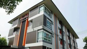 A multi-story building with a modern design, featuring a prominent vertical orange stripe and a sign that reads "GUARD". - Tonsom Residence (Uttaradit)