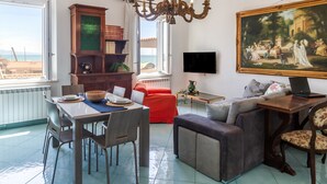 Una sala de estar con una mesa de comedor, sofá y un cuadro en la pared.