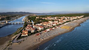 Un pueblo costero con una playa, un puente y edificios residenciales.