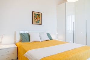 Une chambre à coucher avec un lit, des tables de chevet, une armoire et un tableau au mur.
