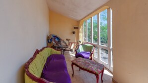 Una habitación iluminada por el sol con una bicicleta, un sofá, una silla y una mesa.