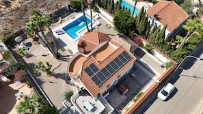 Una propiedad residencial con piscina, paneles solares y un jardín bien cuidado.