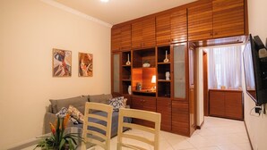 A living room with a sofa, chairs, a wooden cabinet, and artwork on the wall. - SUH Copacabana 71 Princess Beach (Rio de Janeiro)