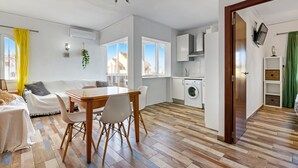 A modern apartment with a dining area, kitchen, and living room. - Apartment 'El Palmar' with Sea View, Wi-Fi and Air Conditioning (Denia)
