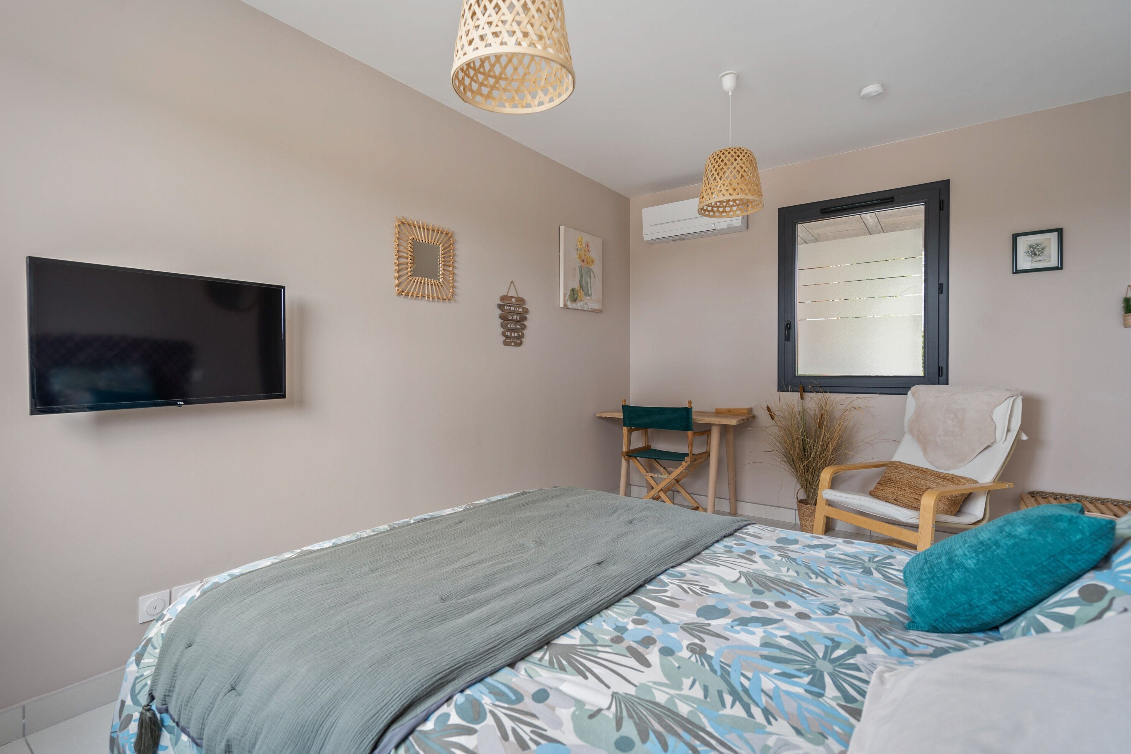 Une chambre à coucher comprenant un lit, une télévision, une chaise, un bureau et des éléments de décoration murale.