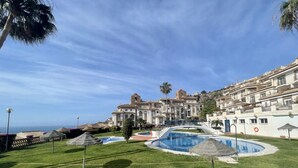 A resort with a swimming pool, palm trees, and a view of the ocean. - Apartment 'Balcón Del Mar' with Sea Views, Wi-Fi and Air Conditioning (La Herradura)