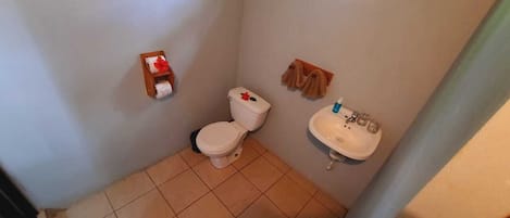 A small bathroom with a toilet, sink, and a towel rack.