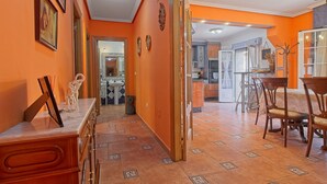 Ein Hotelkorridor mit Essbereich, der einen Tisch und Stühle beinhaltet, einer Küche im Hintergrund und einem Spiegel an der Wand.