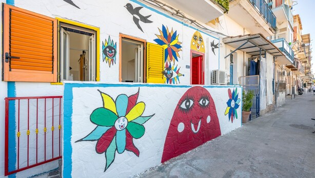 A colorful building with a mural, a red gate, and a balcony. - Holiday Home 'Coscienza' with Sea View, Wi-Fi and Air Conditioning (Palermo)