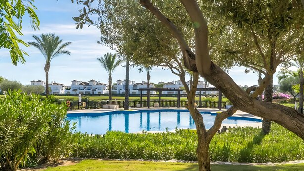 A swimming pool surrounded by greenery and white buildings in the background. - Apartment 'Congrio - Resort Holiday Treat' with Mountain View, Wi-Fi and Air Conditioning (Torre-Pacheco)