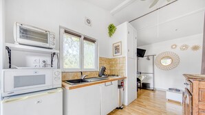 Cocina compacta con microondas, horno y lavaplatos.