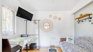 Una sala moderna con una cama, un televisor, un escritorio y un sofá.