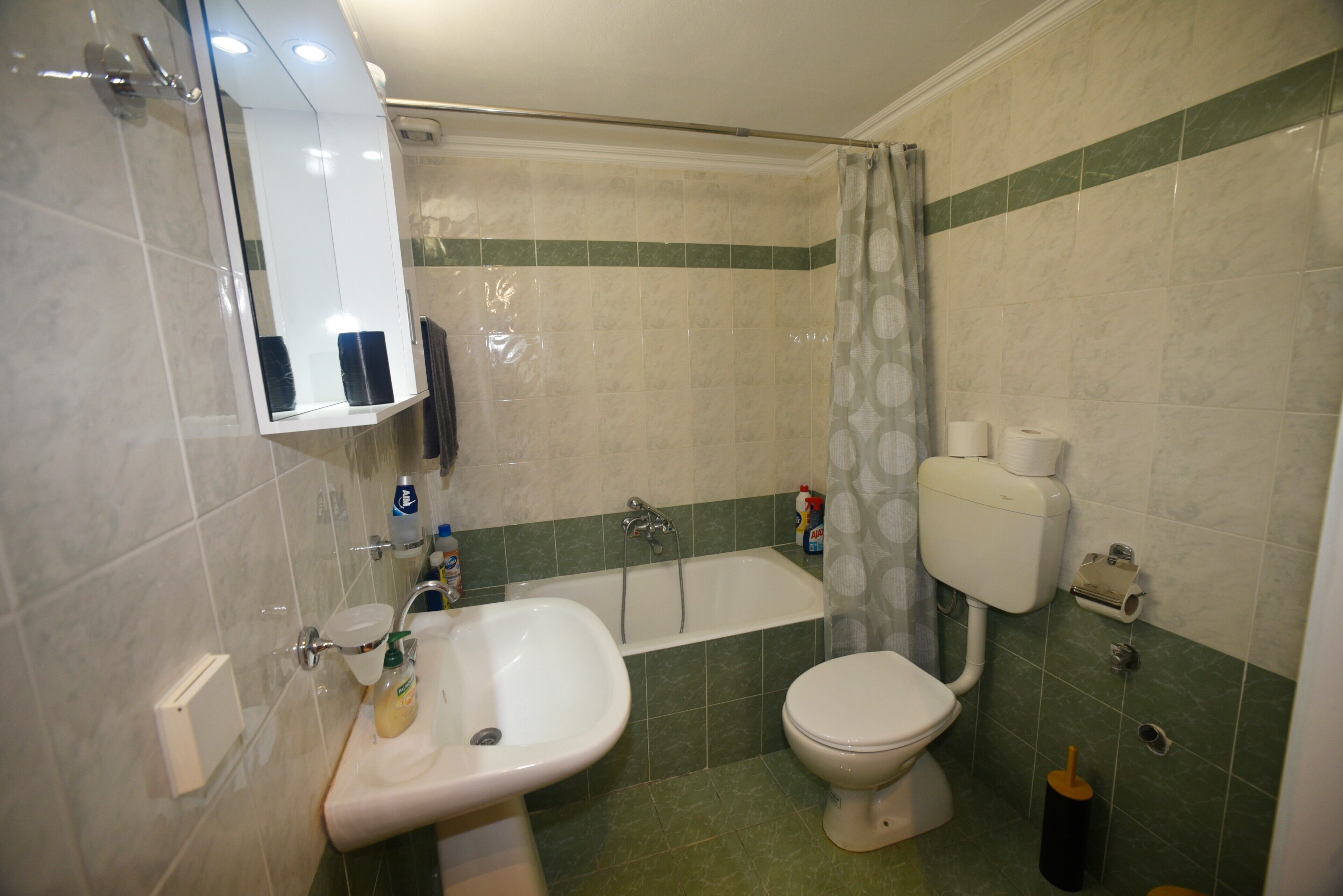 A bathroom with a sink, toilet, bathtub, and a mirror.