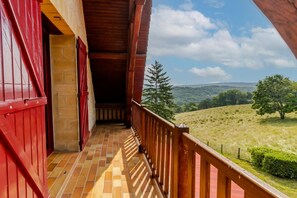 A balcony with a view of a hilly landscape.