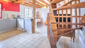 A kitchen with a microwave, a dishwasher, and a dining area with a table and chairs.