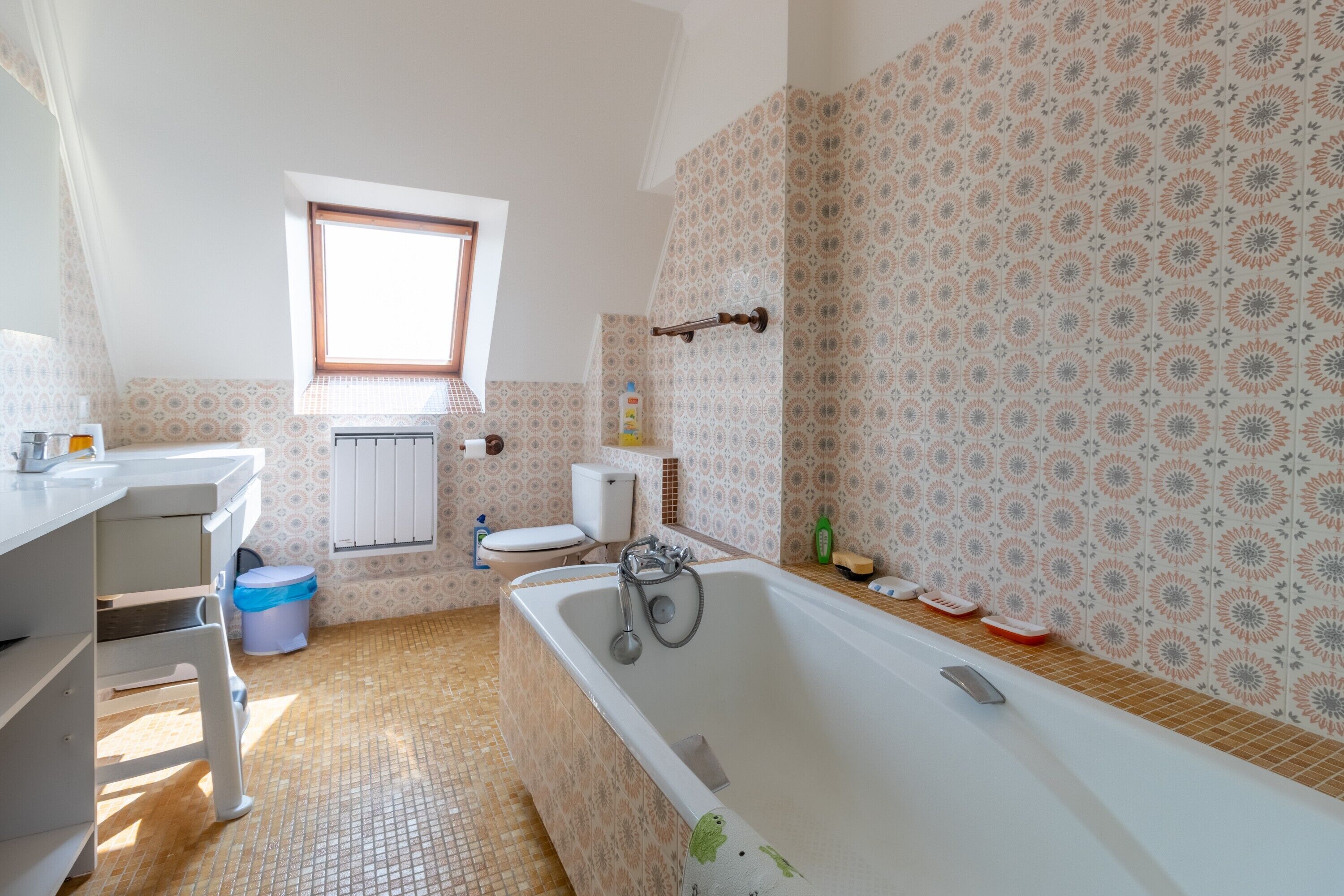 Ein Badezimmer mit Badewanne, Toilette, Waschbecken und Fenster.