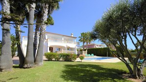 A large house with a swimming pool, surrounded by palm trees and a well-maintained lawn. - Villa 'Cunill' with Sea View, Wi-Fi and Air Conditioning (Llucmajor)