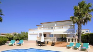 A two-story house with a balcony, a swimming pool, and lounge chairs. - Villa 'Cunill' with Sea View, Wi-Fi and Air Conditioning (Llucmajor)