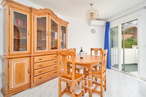 Un coin repas comprenant un buffet en bois, une table ronde et des chaises.