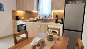 A modern kitchen with wooden cabinets, a built-in oven, a coffee maker, and a refrigerator. - Country House 'Andros - Private Pool' with Sea View, Wi-Fi and Air Conditioning (Andros)