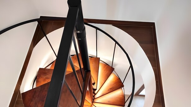 A spiral staircase with wooden steps and a black handrail, leading upwards. - Country House 'Andros - Private Pool' with Sea View, Wi-Fi and Air Conditioning (Andros)