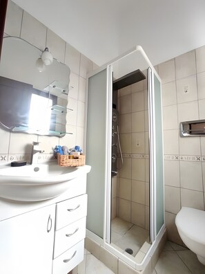 A bathroom with a white sink, a mirror, a shower enclosure, and a toilet. - Country House 'Andros - Private Pool' with Sea View, Wi-Fi and Air Conditioning (Andros)