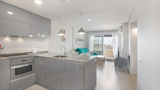 A modern kitchen with a central island, built-in oven, and pendant lighting. - Apartment 'Isla Canela' with Sea View, Wi-Fi and Air Conditioning (Ayamonte)