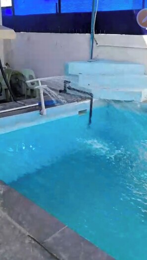 Une piscine avec un plongeoir et des marches permettant d’y descendre.