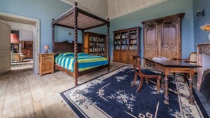 A bedroom with a four-poster bed, a wooden desk, a chair, a bookshelf, and a large wooden cabinet. - The East Wing – Historic Elegance and Modern Comfort at Château de Mayac with Shared Pool (Mayac)