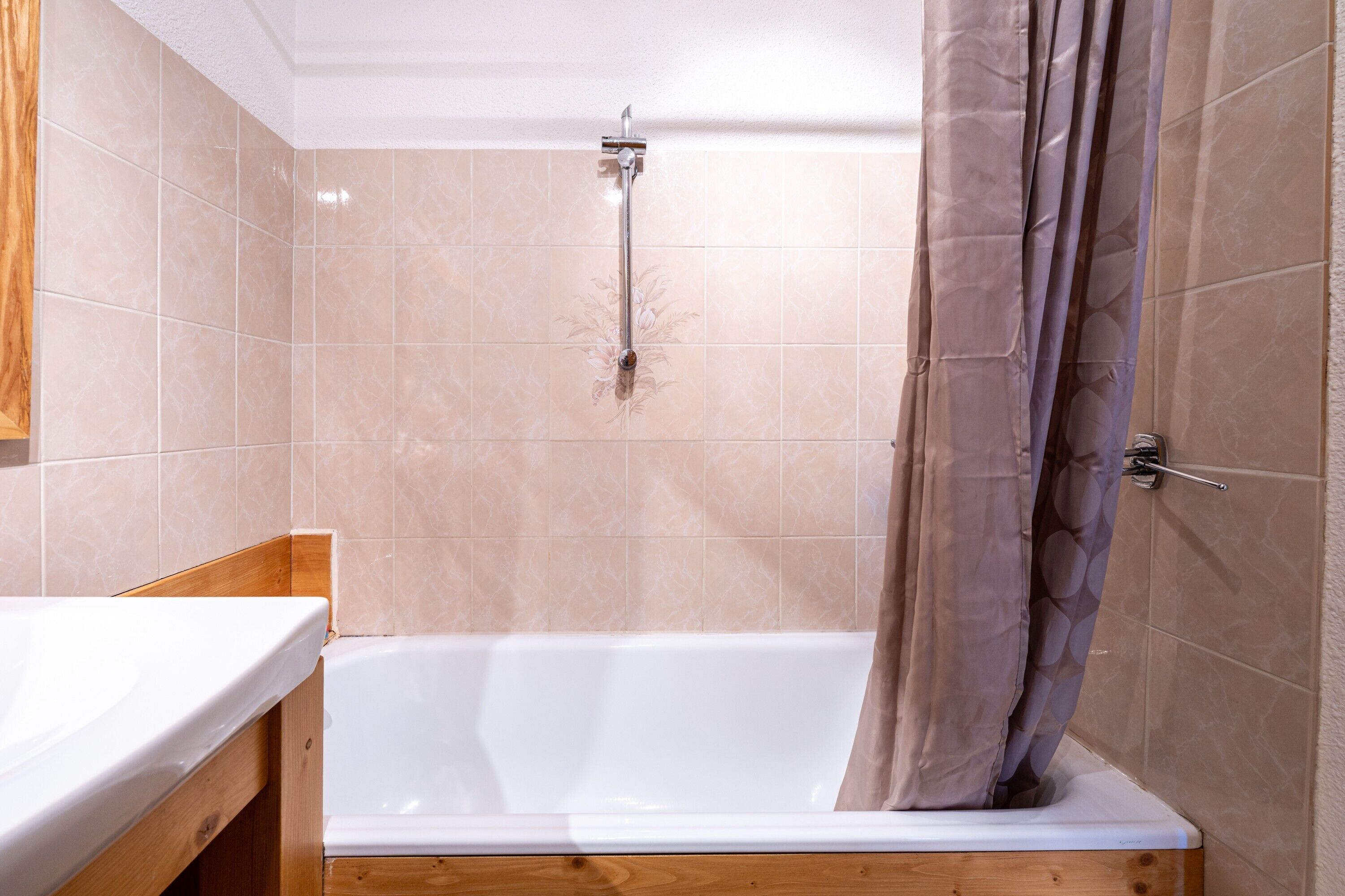 Un baño con bañera, ducha y tocador de madera.