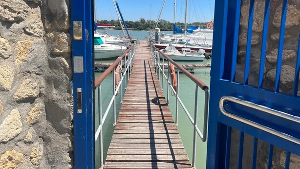 Un muelle de madera que da a un puerto deportivo con barcos amarrados.