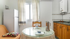 A compact kitchen with a refrigerator, a coffee maker, and a sink.