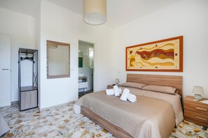 Une chambre à coucher avec un lit, une tête de lit en bois, une table de chevet avec une lampe, un miroir et un tableau accroché au mur.
