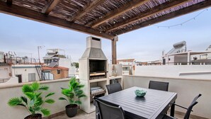 A rooftop patio with a grill, potted plants, and a table with chairs. - Villa Alvor Rooftop with Sea View, Wi-Fi and Air Conditioning (Alvor)
